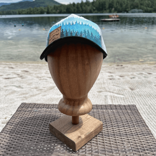 Wear your love for the Adirondacks with this black, white, and teal Taiga Forest Golden Arrow trucker hat