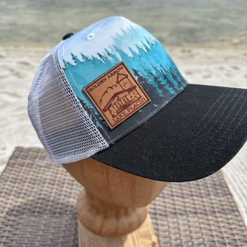 Wear your love for the Adirondacks with this black, white, and teal Taiga Forest Golden Arrow trucker hat